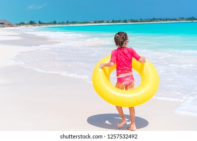 Happy Kid With Inflatable Rubber Ring Having Fun On The Beach Swiming And Splashing