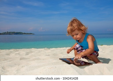 Happy Kid On The Beach Playing Tablet PC