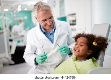 Happy Kid On Dental Chair After Repairing Tooth