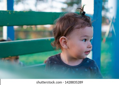 Happy Kid On Kids Playground Playing Hide And Go Seek With Mom. Surprised Child Plays Peek A Boo With Mother Outdoors In Nature. Toddler And Woman Play Games On Sunny Day. Adult Spying On Baby. 