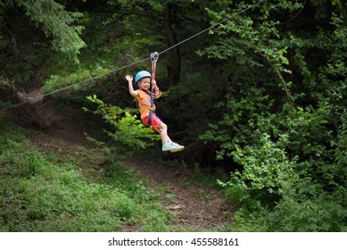 Happy Kid On Zip Line Between Trees