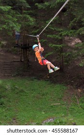 Happy Kid On Zip Line Between Trees