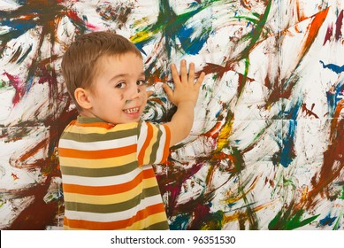 Happy Kid Painting With His Palms A Wall And Looking Back Over Shoulder