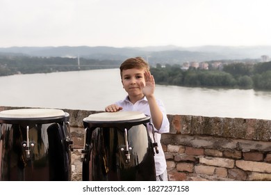 Happy Kid Playing Bongos By The River. 