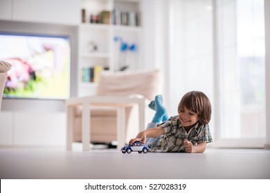 Happy kid playing with old car toy at home - Shutterstock ID 527028319