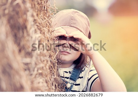 Similar – Junge Frau bedeckt ihr Gesicht vor der Sonne auf einem grünen Feld.