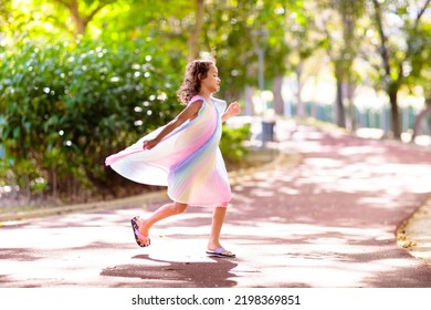 Happy Kid Playing In Summer Park. Little Girl Dancing In Beautiful Dress. Children Run, Spin, Twirl And Laugh. Summer Vacation Fun. School Holiday Activity. Easter Or Child Birthday Party.