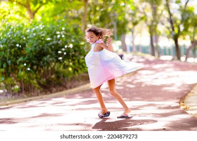 Happy Kid Playing In Summer Park. Little Girl Dancing In Beautiful Dress. Children Run, Spin, Twirl And Laugh. Summer Vacation Fun. School Holiday Activity. Easter Or Child Birthday Party.