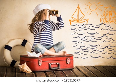 Happy kid playing with toy sailing boat indoors. Travel and adventure concept - Powered by Shutterstock