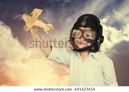 Happy kid playing with toy wooden airplane.