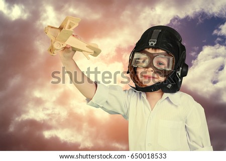 Happy kid playing with toy wooden airplane.