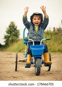 Happy Kid Riding A Bike Outdoors.