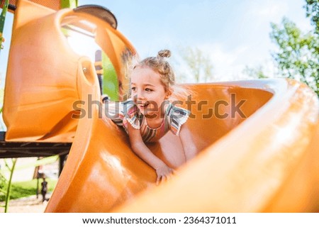 A Happy kid slide on playground on summer season