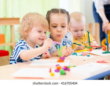 Happy Kids Doing Arts And Crafts In Day Care Centre