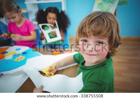 Happy kids doing arts and crafts together at their desk