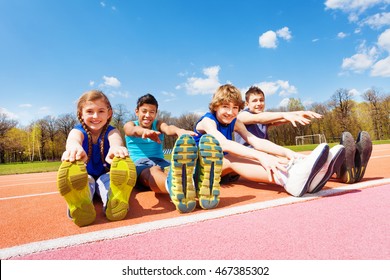 Happy Kids Doing Stretching Exercises On A Stadium