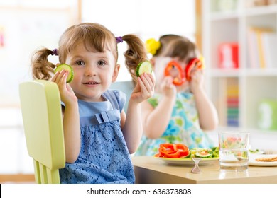 happy kids eating healthy food in kindergarten or at home