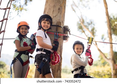 Happy Kids Enjoying Zip Line Adventure On Sunny Day