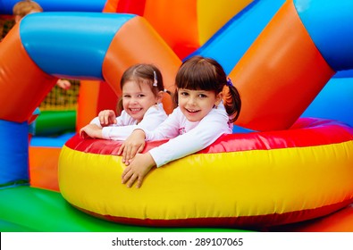 Happy Kids, Girls Having Fun On Inflatable Attraction Playground