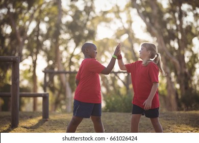 Happy Kids Giving High Five During Obstacle Course In Boot Camp