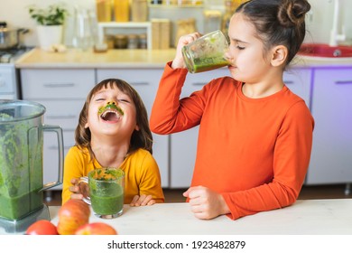 Happy Kids with glass cup of green smoothies in hands. Cute boy and girl crazy drinks healthy dietary nutritious cocktail at home in the kitchen. Healthy lifestyle, raw food - Powered by Shutterstock