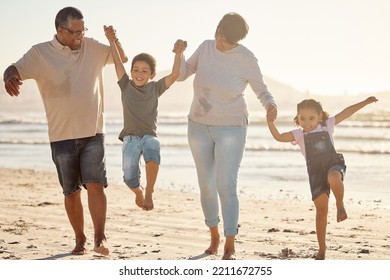 Happy, Kids And Grandparents With Energy And Jump Playing At The Beach On A Fun Family Day At Sea On Holiday Vacation Together. Excited Children Bonding With Their Grandmother And Grandfather Outdoor