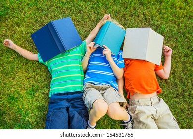 Happy Kids, Group Of Young Boys Reading Books Outside Together After School