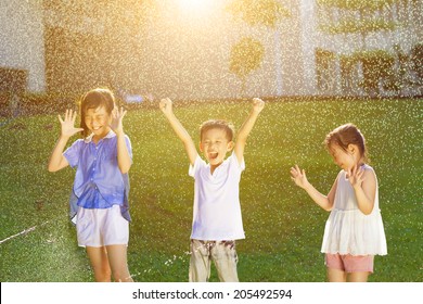 Happy Kids Has Fun Playing In Water Fountains