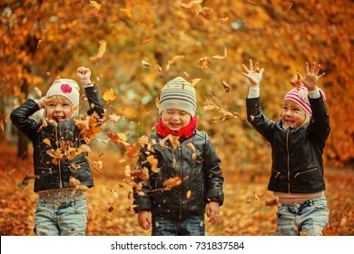 Happy Kids Having Fun With Leaves In Autumn Park.