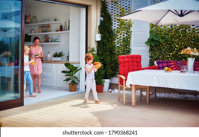 Happy Kids Helping Mother To Lay Up The Table At The Summer Patio, Family Lifestyle