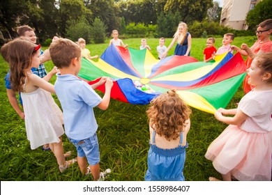 Happy kids holding parachute during funny game
