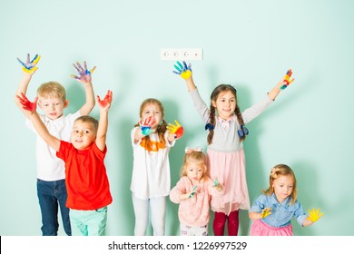 Happy kids holding their colored hands up