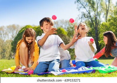 Happy kids juggling with little balls in the park