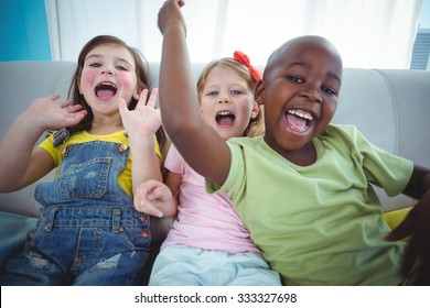 Happy Kids Laughing While Sitting Down On The Couch