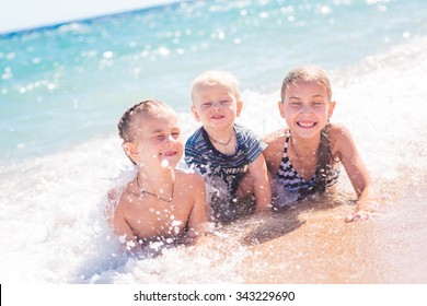 Happy Kids On The Beach Having Fun