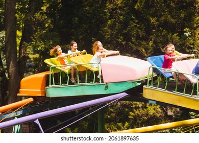 The Happy Kids On A Roller Coaster In The Amusement Park