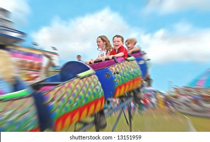 Happy Kids On Rollercoaster At Amusement Park