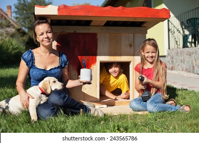 Happy Kids Painting The Doghouse To Shelter Their New Labrador Puppy