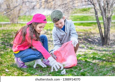 Happy Kids Picking Up Trash In The Spring Park