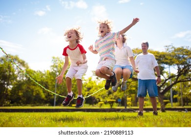 Happy kids play outdoor. Children skipping rope in sunny garden. Summer holiday fun. Group of school children playing in park playground. Healthy outdoors activity. Sport for child. - Shutterstock ID 2190889113
