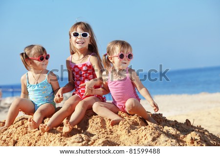 Happy kids playing at the beach in summer