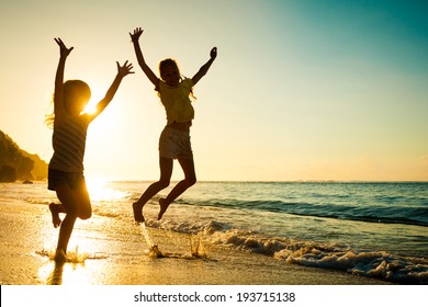 Happy Kids Playing On Beach At The Sunrise Time