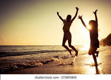 Happy Kids Playing On Beach At The Sunrise Time