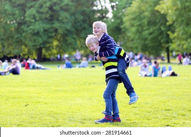 Happy Kids Playing In The Park On Beautiful Summer Sunny Day. Two School Boys, Twin Brothers, Jumping And Running Together In Hyde Park, London, UK. Brotherhood And Friendship Concept.