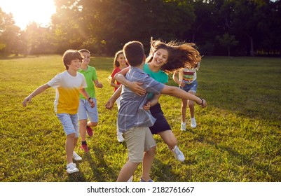 Happy kids playing tag in the park. Group of joyful, excited children running on green lawn, trying to catch each other, enjoying good weather, and having great time together. Summer vacation concept - Shutterstock ID 2182761667