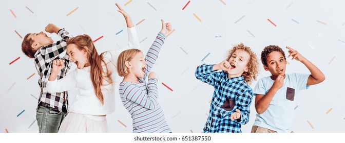 Happy Kids Pretending To Sing At The School Party