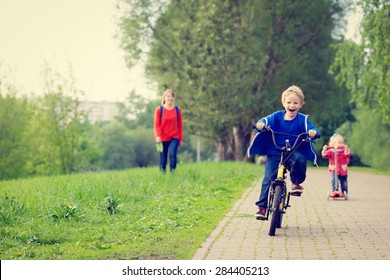 Happy Kids Riding Scooter And Bike In The Park, Family Sport