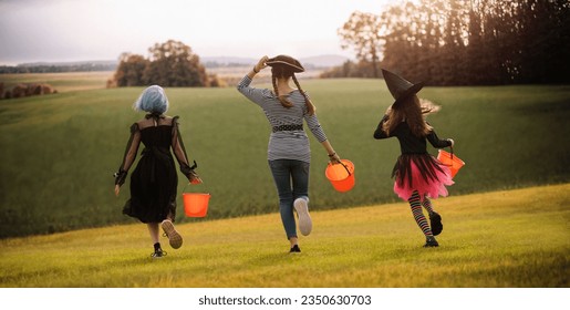 Happy kids are running to Halloween party. Children are wearing carnival costumes. - Shutterstock ID 2350630703