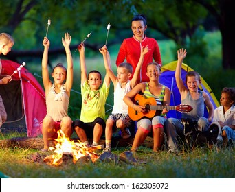 Happy Kids Singing Songs Around Camp Fire