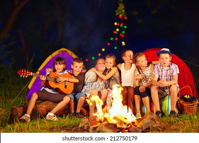 Happy Kids Singing Songs Around Camp Fire